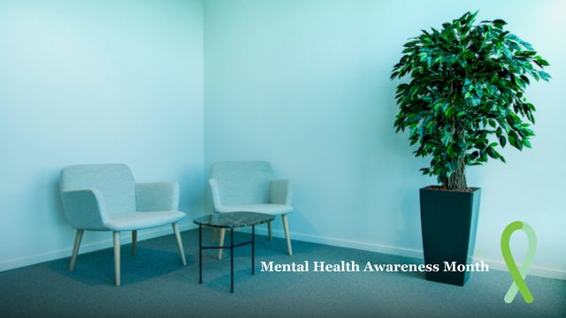 Office corner photo background with the words Mental Health Awareness Month and a green ribbon